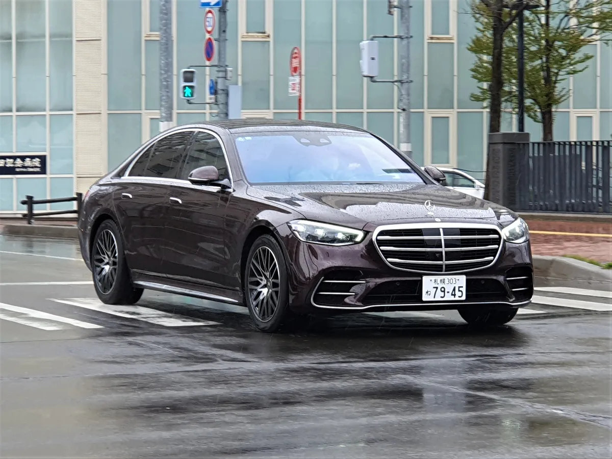 Black Mercedes S-Class limousine driving through a city street